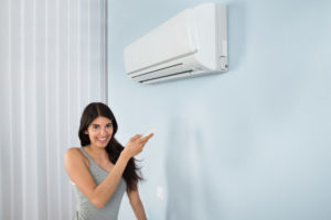 Woman Turning On Ductless Ac