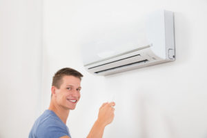 Man Smiling In Front Of Ductless Mini Split System