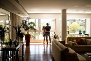 Couple Looking Out Window In Home